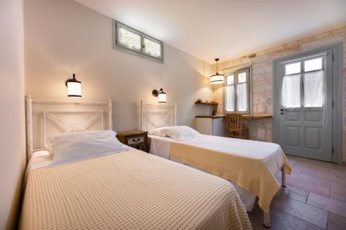 a bedroom with two beds and a door at Monachofolitses in Kimolos