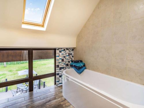 a bathroom with a tub and a large window at 2 bed in Chepstow 87781 in Wolves Newton