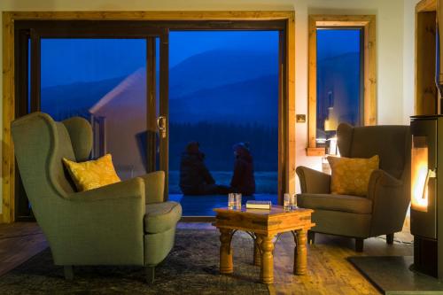a living room with two chairs and a table at Luxury Cabins at Glenorchy Farm in Dalmally