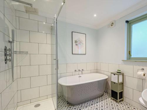 a bathroom with a tub and a glass shower at 3 Bed in Kippford 88274 in Kippford