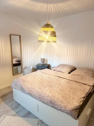 a bedroom with a bed and a chandelier at Stadtbude 50 in Emden