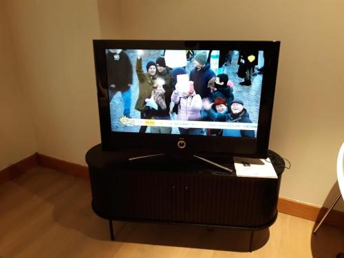 uma televisão de ecrã plano com um grupo de pessoas em Apartment Testerep in Westende-Bad 150 m van het strand met garage voor 5 personen em Middelkerke
