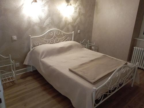 un letto bianco in una camera da letto con due luci di Le Gite d'Auvergne a Lanobre