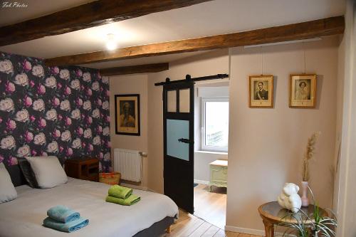 1 dormitorio con 1 cama y una pared con flores en Belgica-Melay 52400, en Melay