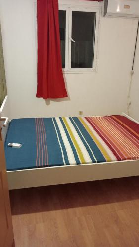 Ce lit se trouve dans un dortoir doté d'une fenêtre. dans l'établissement Le zami ola, à Trois Bassins