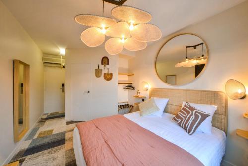 1 dormitorio con 1 cama grande y espejo grande en B Hôtel Olympia Bourges - Hotel Rénové avril 2024, en Bourges
