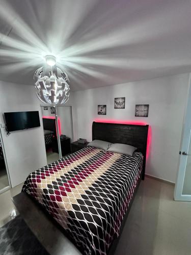 a bedroom with a bed with a colorful comforter at private apartmento airport 7 minutes y de la playa in Carolina