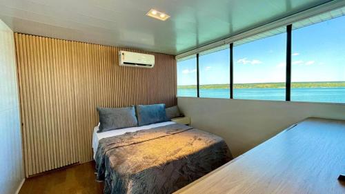 1 dormitorio con cama y ventana grande en WTS HOUSE BOAT en Brasilia