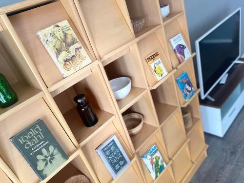 a wooden book shelf filled with books and other items at Kodikas huoneisto Kuopiossa in Kuopio