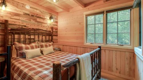 a bedroom with a bed in a log cabin at The Magnolia in Treehouse Grove at Norton Creek in Gatlinburg
