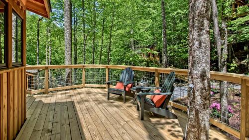 a wooden deck with two chairs and a table at The Hemlock in Treehouse Grove at Norton Creek in Gatlinburg