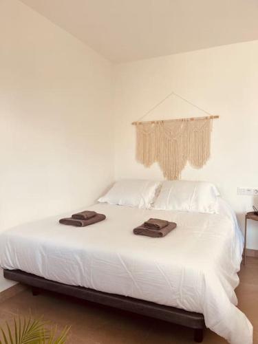 Una cama blanca con dos toallas encima. en Casa Plaza 1, en Vega de Río de Palmas