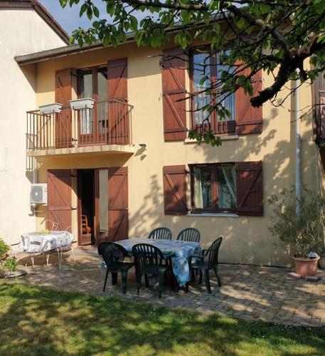 une table et des chaises devant une maison dans l'établissement maison proche du lac, à Aix-les-Bains