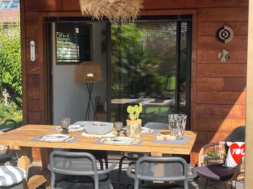 una mesa de madera y sillas en un patio en Villa Marie en Sévrier