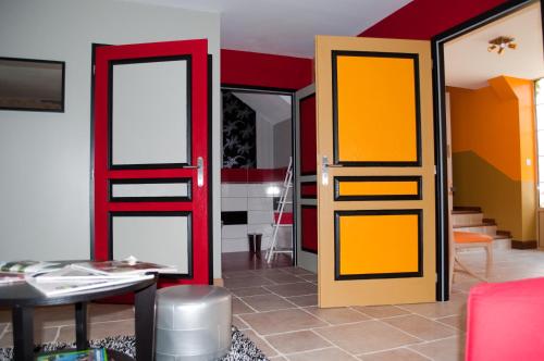Chevagnes的住宿－LE GOÛT DES CHOSES，一间设有橙色和黄色门和桌子的房间