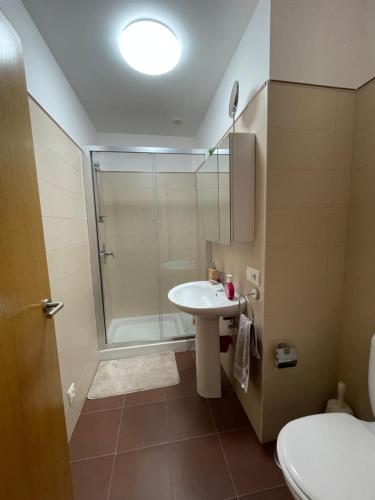 a bathroom with a shower and a sink and a toilet at APARTAMENTO CON EXCELENTES VISTAS AL MAR EN LA PLAYA DE CARNOTA in Caldebarcos