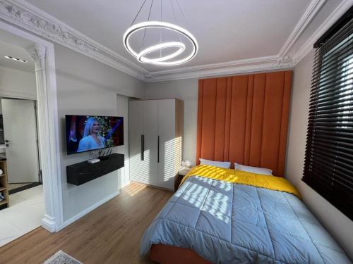 um quarto com uma cama e uma televisão de ecrã plano em Leti Apartments M.Shyri2 em Tirana