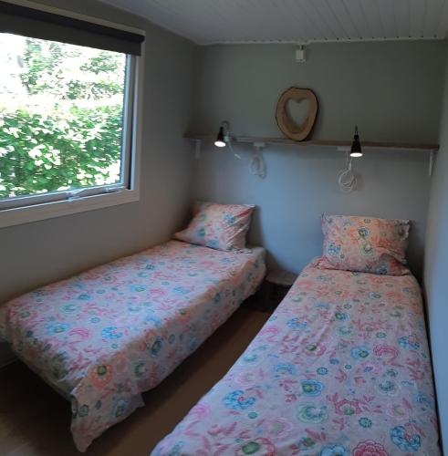 ein Schlafzimmer mit zwei Betten und einem Fenster in der Unterkunft Chalet Hoenderloo Den in Hoenderloo