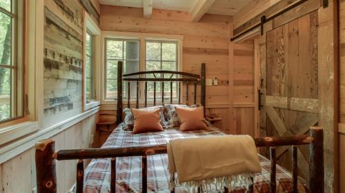 a bedroom with a bed in a log cabin at The Cedar in Treehouse Grove at Norton Creek in Gatlinburg