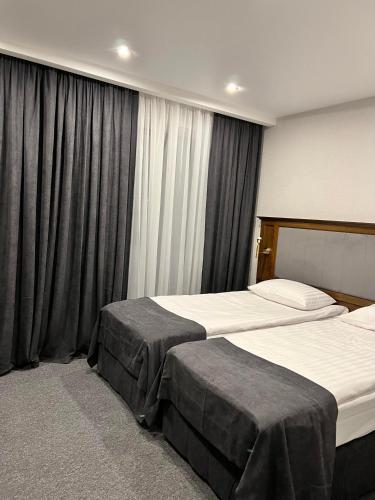 2 camas en una habitación de hotel con cortinas en Хмеляр en Dubno