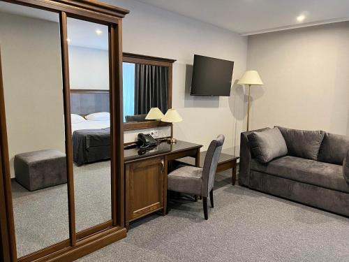 a hotel room with a desk and a bed and a mirror at Хмеляр in Dubno