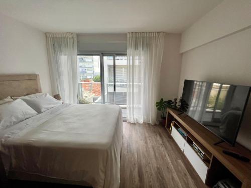 um quarto com uma cama e uma televisão de ecrã plano em Neo Buxareo 315 - World Trade Center em Montevidéu