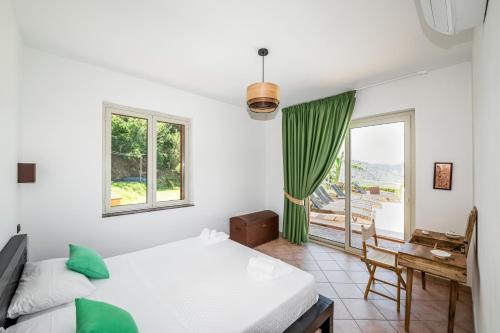een slaapkamer met een bed, een tafel en een raam bij Delightful 4 Bed Villa with Heated pool & Jacuzzi Overlooking Aeolian Islands in Castroreale