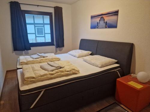 Bett in einem kleinen Zimmer mit Fenster in der Unterkunft Apartment Am Sternberg 236 in Frankenau