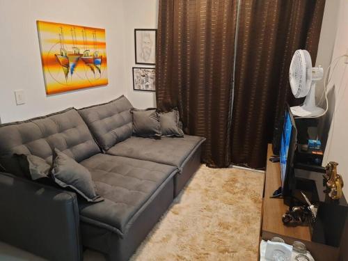 a living room with a gray couch in a room at Apartamento para Negócios e Lazer no Aeroporto in Sao Jose do Rio Preto