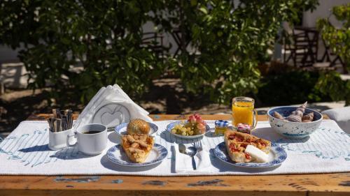 una mesa con platos de comida y bebidas. en Monachofolitses, en Kimolos