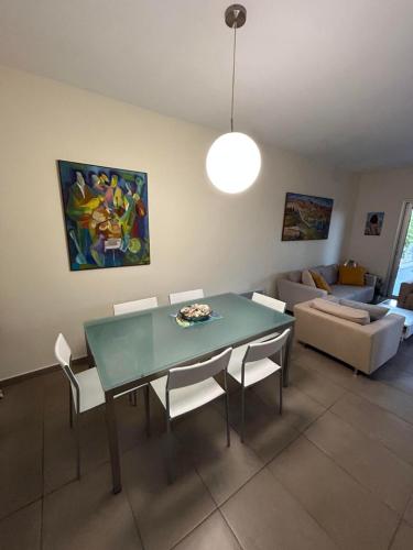 a dining room with a green table and white chairs at Beautiful maisonette in Protaras in Protaras