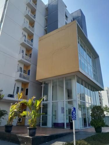 um edifício alto com uma placa de estacionamento em frente em DND Room Aero em Teko