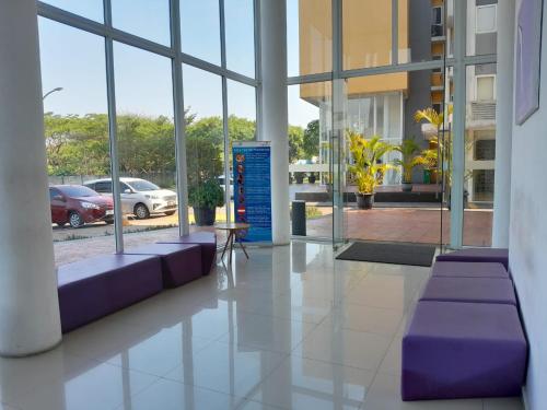 a lobby with purple couches in a building with windows at DND Room Aero in Teko