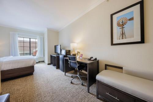 a hotel room with a bed and a desk with a computer at Comfort Suites Lawton Near Fort Sill in Lawton