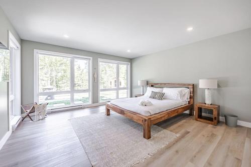 um quarto com uma cama e uma grande janela em Le Montagnard Spa Sauna Piscine Privés em Brownsburg