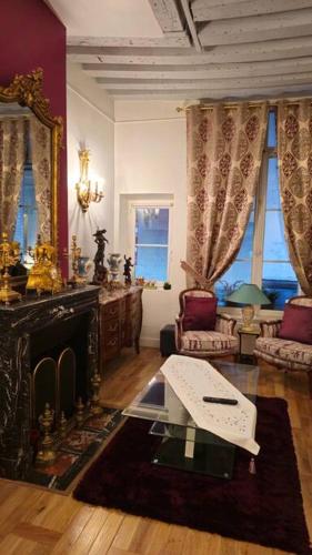 un salon avec une cheminée et une table dans l'établissement Very Chic Flat Paris VI, à Paris
