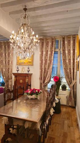 une salle à manger avec une table et un lustre dans l'établissement Very Chic Flat Paris VI, à Paris