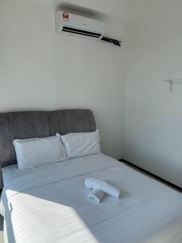 a bed with two towels laying on top of it at Urban Suites Georgetown by BNB4U in Jelutong