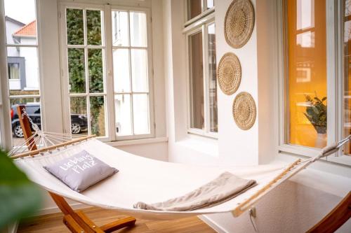 - un hamac blanc dans une chambre avec fenêtres dans l'établissement VILLA I 100m Kurpark I Wintergarten Boxspringbett I NETFLIX, à Bad Salzuflen