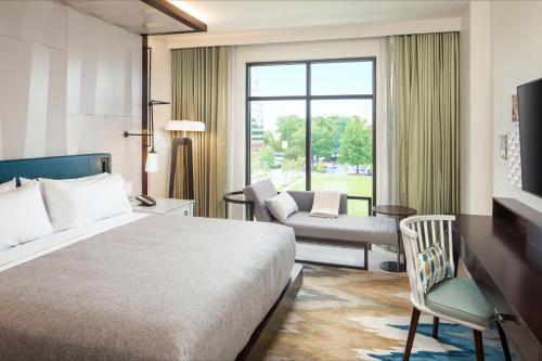 a hotel room with a bed and a window at Canopy By Hilton Charlotte SouthPark in Charlotte