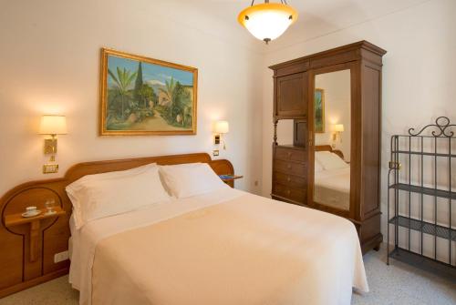 a bedroom with a bed and a dresser and a mirror at Villa Schuler Taormina GARDEN SUITE IN SELF-CATERING in Taormina