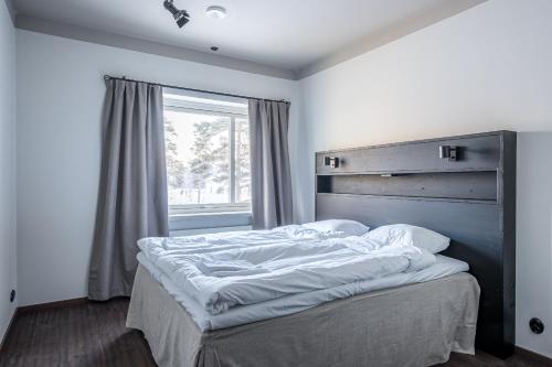 a bed in a bedroom with a large window at Hotell Grelsby Strand in Godby