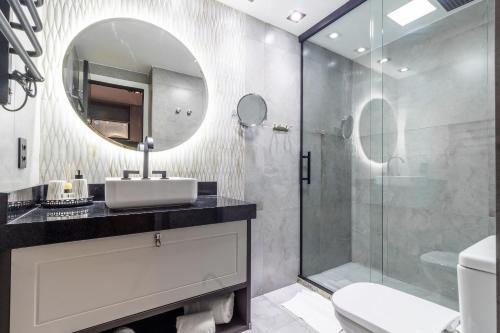 a bathroom with a sink and a shower with a mirror at Flat 1111 WCT Berrini Brooklin in Sao Paulo