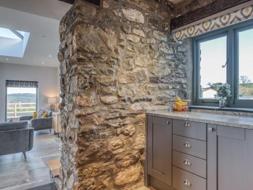 a kitchen with a stone wall and a counter top at 4 Bed in Denbigh 76475 in Llannefydd