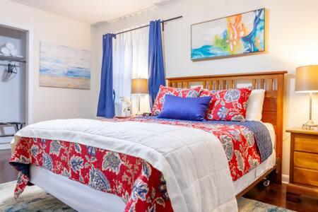 a bedroom with a bed with red and blue pillows at Modern Chic 2-Bedroom Apartment in Atlanta