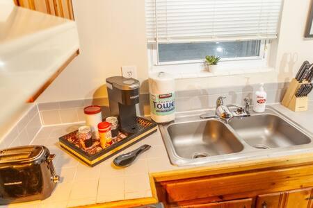 a kitchen counter with a sink and a coffee maker at Modern Chic 2-Bedroom Apartment in Atlanta
