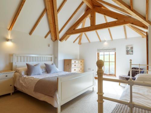 1 dormitorio con 1 cama en una habitación con vigas en 3 Bed in Crackington Haven 78271, en Saint Gennys