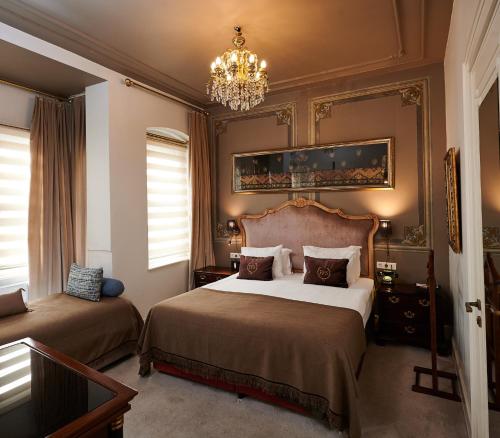 a bedroom with two beds and a chandelier at Faik Pasha Hotels Special Category Beyoglu Istanbul in Istanbul