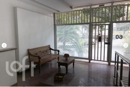 a living room with a bench and a large window at Apartamento Aconchegante na Zona Sul, Botafogo Rj in Rio de Janeiro