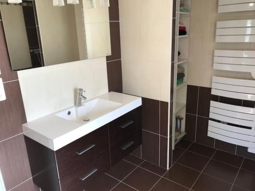 une salle de bain avec un lavabo blanc et une douche dans l'établissement MAISON NOTRE DAME DE MONTS, à Notre-Dame-de-Monts